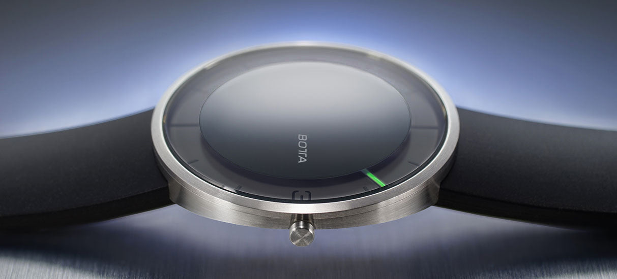 Nahaufnahme der BOTTA NOVA Quarzuhr in Schwarz mit seitlicher Ansicht des Edelstahlgehäuses. Das minimalistische Design betont den fließenden Übergang von Glas und Gehäuse, während der einzelne grüne Zeiger das Konzept der Einzeigeruhr klar hervorhebt. Diese elegante Designuhr reduziert die Zeit auf das Wesentliche und kombiniert modernes Understatement mit technischer Präzision. Eine besondere Armbanduhr mit nur einem Zeiger – jetzt online kaufen oder bestellen.