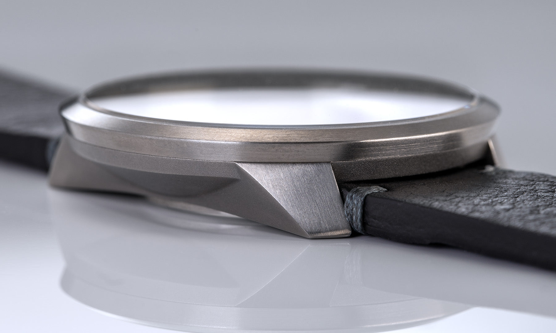 Das Bild zeigt die UNO 24 Automatik von BOTTA in einer Nahaufnahme des Gehäuses. Zu sehen ist die präzise gearbeitete Titanarchitektur mit klaren Kanten und satiniertem Schliff sowie das angesetzte schwarze Lederarmband. Diese Automatikuhr verbindet modernes Design mit technischer Raffinesse. Als Einzeigeruhr stellt sie die Zeit im 24h-Format dar – logisch, reduziert und einzigartig. Eine exklusive Designuhr für Anspruchsvolle, die eine besondere Armbanduhr kaufen oder bestellen möchten.