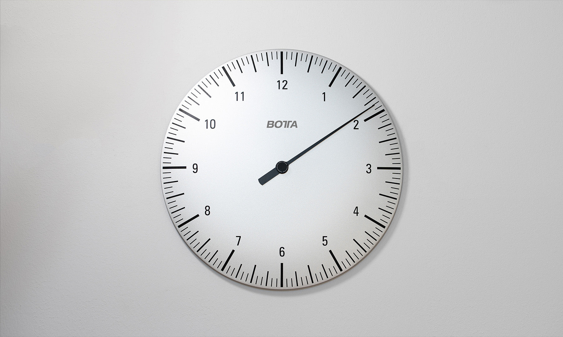 BOTTA UNO Wanduhr, eine hochwertige Designwanduhr mit einem Durchmesser von 50 cm  aus massivem Aluminium. Das puristische Zifferblatt ist weiß und auf das Wesentliche reduziert: ein einziger schwarzer Stundenzeiger. Diese Einzeigeruhr vermittelt Gelassenheit, Ruhe und ein völlig neues Zeitgefühl. Wer eine außergewöhnliche Wanduhr mit einem Zeiger kaufen oder bestellen möchte, findet hier eine Designuhr, die zeitlose Eleganz mit moderner Uhrmacherkunst verbindet.