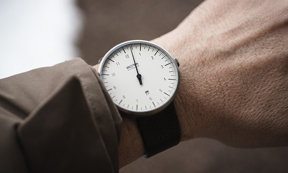 BOTTA UNO Automatik als Armbanduhr. Das klare weiße Zifferblatt mit einem schwarzen Zeiger macht das Prinzip der Einzeigeruhr sichtbar, das eine entspannte Ablesbarkeit ermöglicht. Das Titan-Gehäuse ist schlank und elegant. Diese Automatikuhr mit zuverlässigen Sellita SW 200-1 Automatikwerk, kratzfestem Saphirglas und edler Verarbeitung ist nicht nur eine Designuhr, sondern ein Statement für Individualität. Wer eine Armbanduhr mit einem Zeiger kaufen oder bestellen möchte, findet hier ein modernes Original.