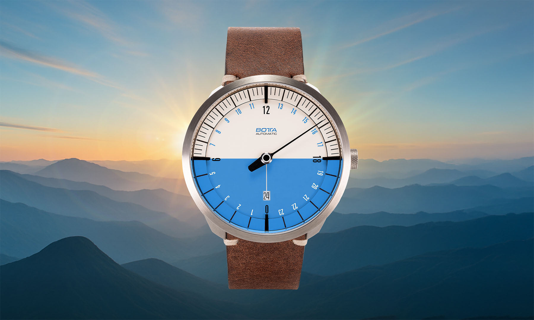 Vor der Kulisse eines Sonnenaufgangs über Berggipfeln präsentiert sich die BOTTA UNO 24 Your Time – eine hochwertige Automatikuhr mit blau-weißem Zifferblatt und braunem Lederband. Als 24-Stunden Uhr mit einem Zeiger folgt sie dem Lauf der Sonne und zeigt den gesamten Tag auf einen Blick. Diese Einzeiger Automatikuhr verbindet Logik, Ästhetik und deutsche Handwerkskunst. Jetzt kaufen oder bestellen und Zeit im Einklang mit der Natur erleben.