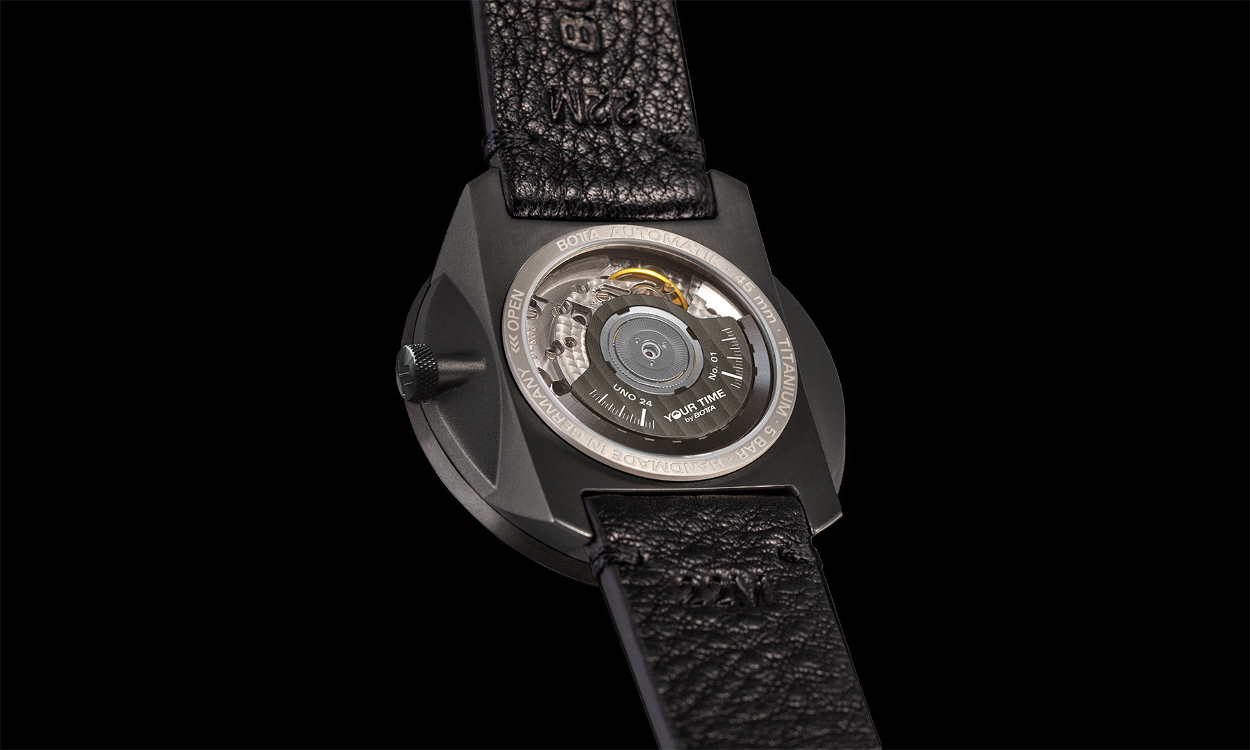 Rückansicht der BOTTA UNO 24 Your Time Automatikuhr im All-Black-Design. Durch den Glasboden des Titan-Gehäuses ist das Schweizer Automatikwerk sichtbar, inklusive des nummerierten „Your Time“-Rotors. Diese hochwertige Automatikuhr ist eine 24-Stunden Uhr mit einem Zeiger und verbindet technische Raffinesse mit markantem Design. Eine Einzeiger Automatikuhr Made in Germany – jetzt kaufen oder bestellen und außergewöhnliche Uhrmacherkunst erleben.