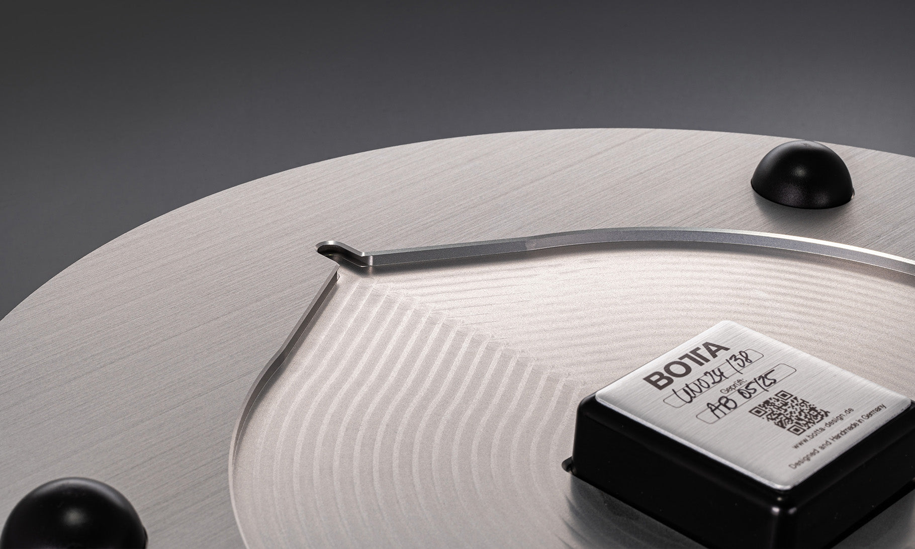 Rückansicht der UNO 24 Slate Designwanduhr von BOTTA: Zu sehen ist das präzise Quarzwerk mit Edelstahlabdeckung, Gravur und QR-Code sowie die stabile Aufhängung für die Wandmontage. Die feine Bürstung des Metalls unterstreicht den hochwertigen Charakter. Diese 24-Stunden Wanduhr im Schieferdesign vereint technische Präzision mit minimalistischer Eleganz. Jetzt die exklusive Designwanduhr kaufen oder bestellen