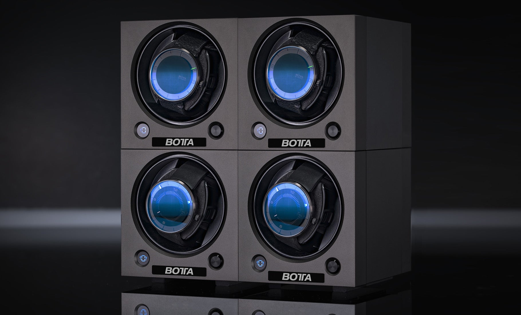 Das Bild zeigt den BOTTA Uhrenbeweger für vier Uhren in modernem, modular stapelbarem Design. Vier Fächer mit blau beleuchteten Designeruhren sind in zwei Reihen angeordnet. Der Vier Uhrenbeweger überzeugt durch präzise Technik, leisen Lauf und ein elegantes, minimalistisches Gehäuse. Ideal für Sammler, die mehrere Automatikuhr-Designuhren sicher aufbewahren und stilvoll präsentieren möchten. Jetzt Uhrenbeweger kaufen oder bestellen.