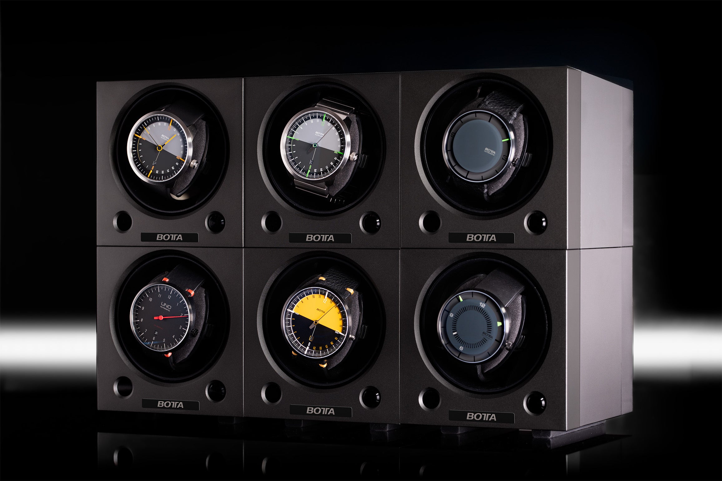 Abgebildet ist ein BOTTA Uhrenbeweger für sechs Uhren im modularen Cube-Design. In den sechs einzeln rotierenden Fächern sind verschiedene BOTTA Automatikuhren platziert, die durch das integrierte Schienensystem synchron betrieben werden. Das edle schwarze Gehäuse dient zugleich als Uhrenbox. Ideal für Sammler, die einen hochwertigen Uhrenbeweger für Designeruhren kaufen oder bestellen möchten – stilvoll, funktional und technisch präzise.