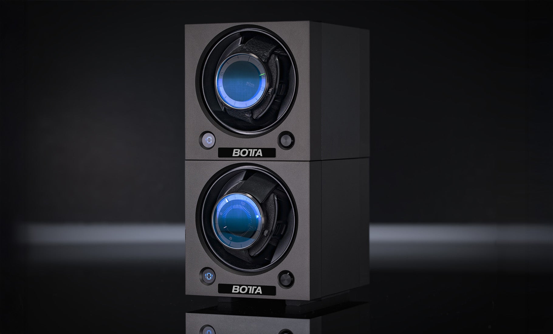 Abgebildet ist der BOTTA Uhrenbeweger für 2 Uhren – Cube, modular, stapelbar und ideal für Ihre Automatikluhren. Das Bild zeigt zwei übereinandergestapelte Module im schwarzen Aluminiumgehäuse mit blauer LED-Beleuchtung, die je eine Automatikuhr sicher halten. Der Zwei-Uhrenbeweger bietet neun Bewegungsprogramme (600–1800 Umdrehungen/Tag), läuft nahezu geräuschlos und kann per USB-Kabel oder Batterie betrieben werden. Perfekte Uhrenbox für Automatikliebhaber – jetzt kaufen oder bestellen