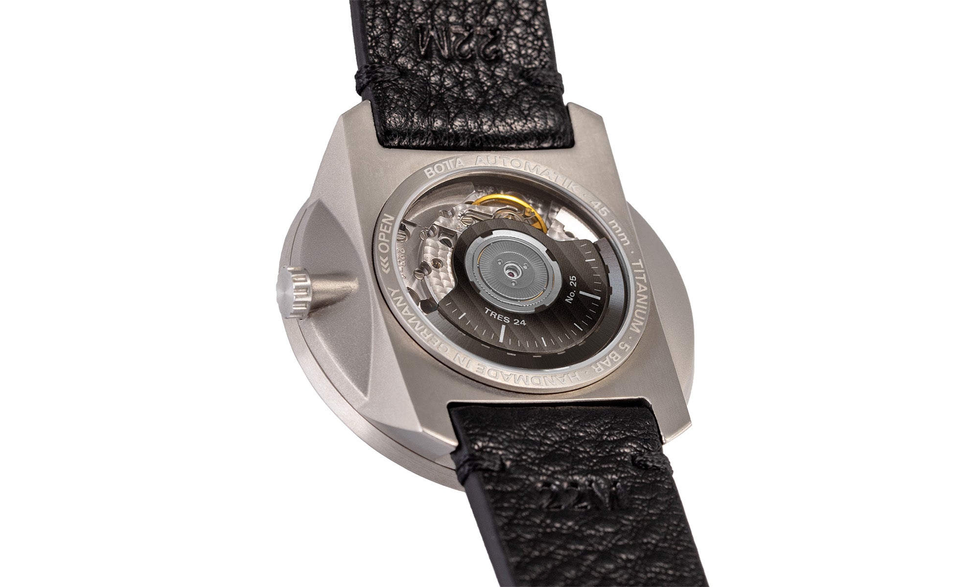 Zu sehen ist die Rückseite der BOTTA TRES 24, einer innovativen Automatikuhr mit 24-Stunden-Anzeige. Das Bild zeigt das geöffnete Titangehäuse mit Glasboden, durch den das mechanische Uhrwerk und der schwarze Rotor sichtbar sind. Feine Gravuren wie „Automatik – 45 mm – Titan – Handmade in Germany“ betonen den Anspruch an höchste Qualität. Diese Designuhr ist nicht nur eine Armbanduhr mit besonderem Konzept, sondern auch ein Meisterwerk deutscher Uhrmacherkunst.