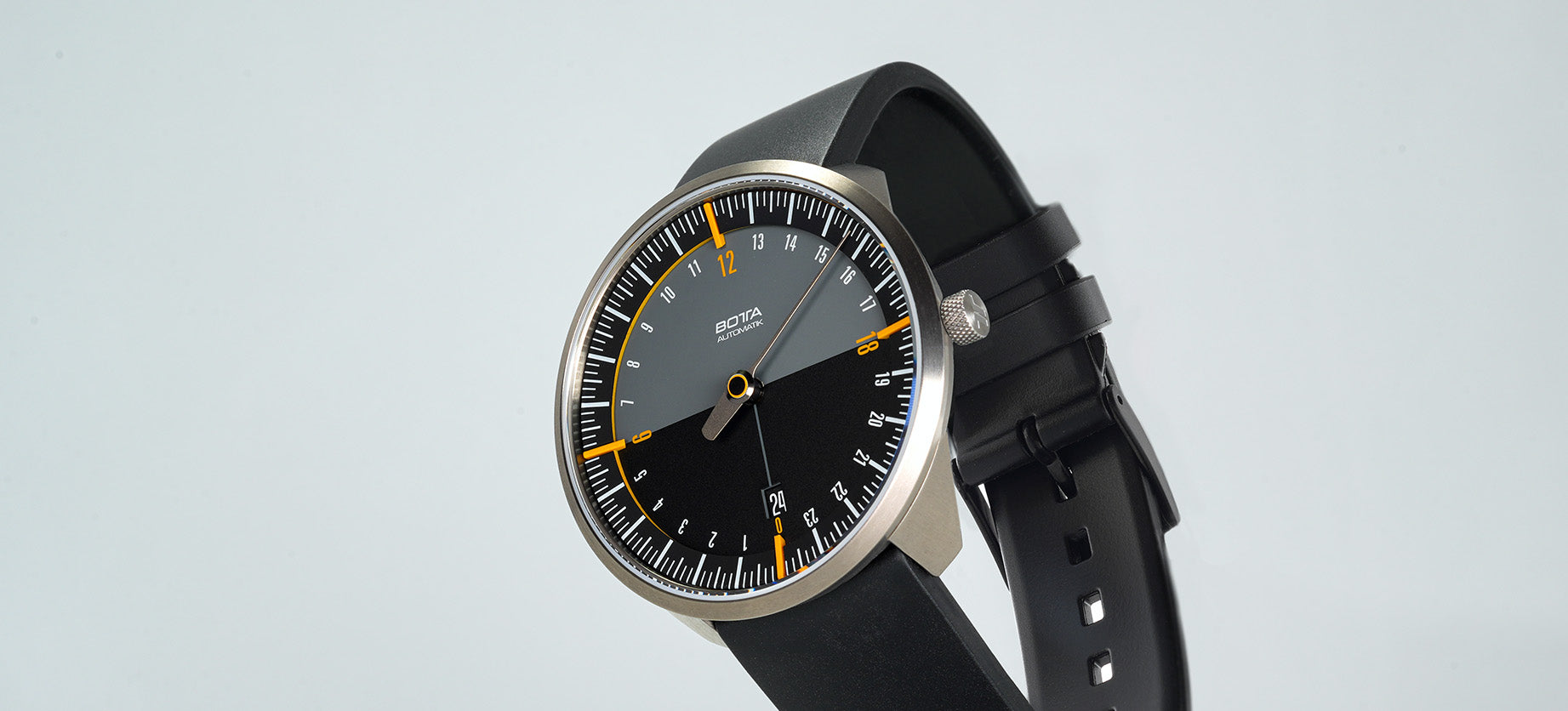 Das Bild zeigt die BOTTA UNO 24 Automatik, eine Einzeigeruhr mit schwarzem Zifferblatt und gelben Akzenten. Das 24-Stunden-Prinzip stellt den gesamten Tagesverlauf mit nur einem Zeiger dar. Diese Automatikuhr kombiniert minimalistisches Design mit technischer Präzision. Im Tri-Titan-Gehäuse arbeitet das Swiss-Made Sellita SW330 Werk, geschützt von doppelt gewölbtem Saphirglas. Eine hochwertige Designuhr für Individualisten, die eine besondere Armbanduhr mit einem Zeiger kaufen oder bestellen möchten.