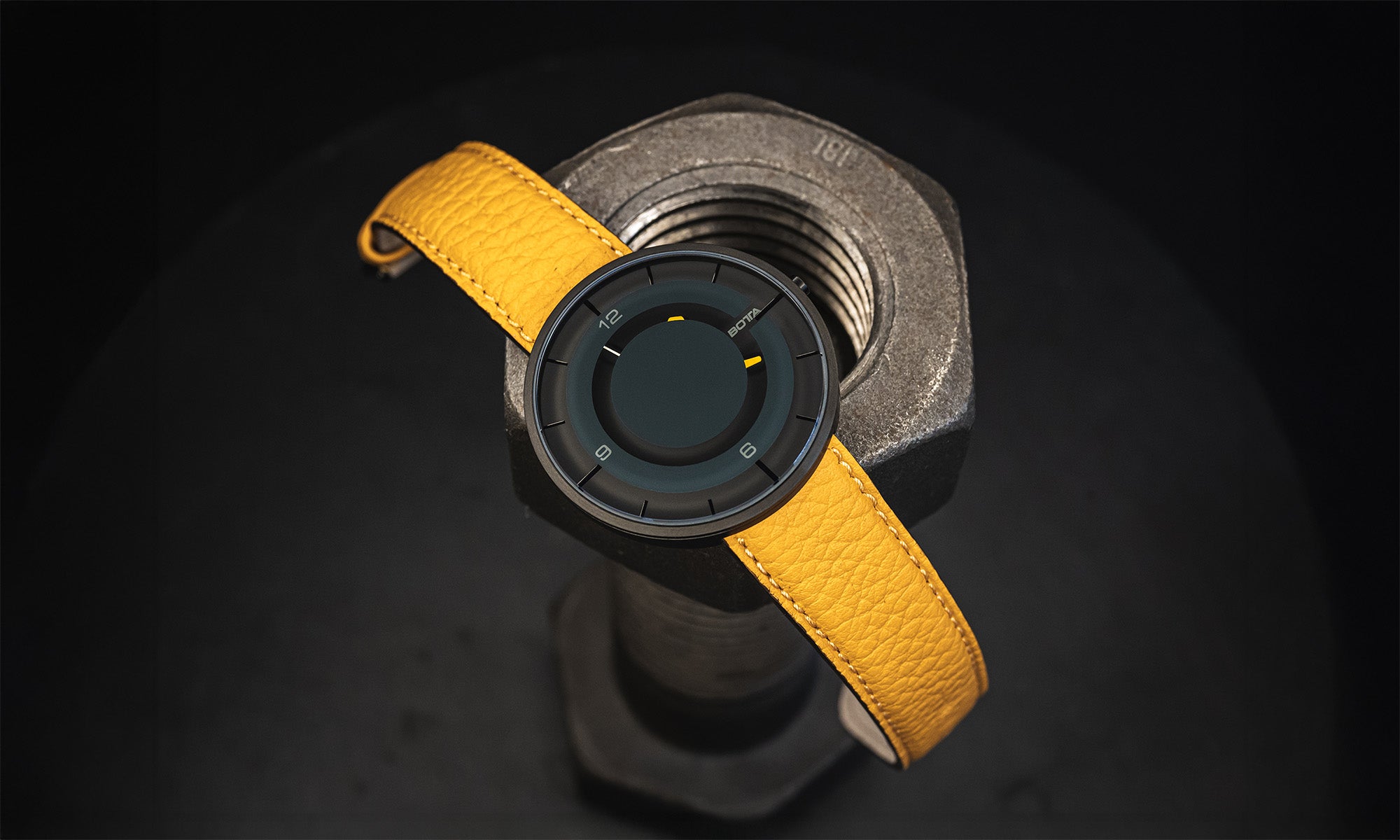 Die BOTTA CLAVIUS Quarzuhr zeigt sich hier mit markantem gelbem Lederarmband als stilvolle Einzeigeruhr. Das futuristische 3D-Zifferblatt mit reduzierter Anzeige macht die Uhr mit einem Zeiger zu einer einzigartigen Designuhr. Das Tri-Titan-Gehäuse kombiniert Leichtigkeit mit Robustheit, kratzfestes Saphirglas sorgt für Klarheit. Diese außergewöhnliche Armbanduhr verbindet Technik und Emotion – ideal für alle, die eine besondere Quarzuhr kaufen oder bestellen möchten.