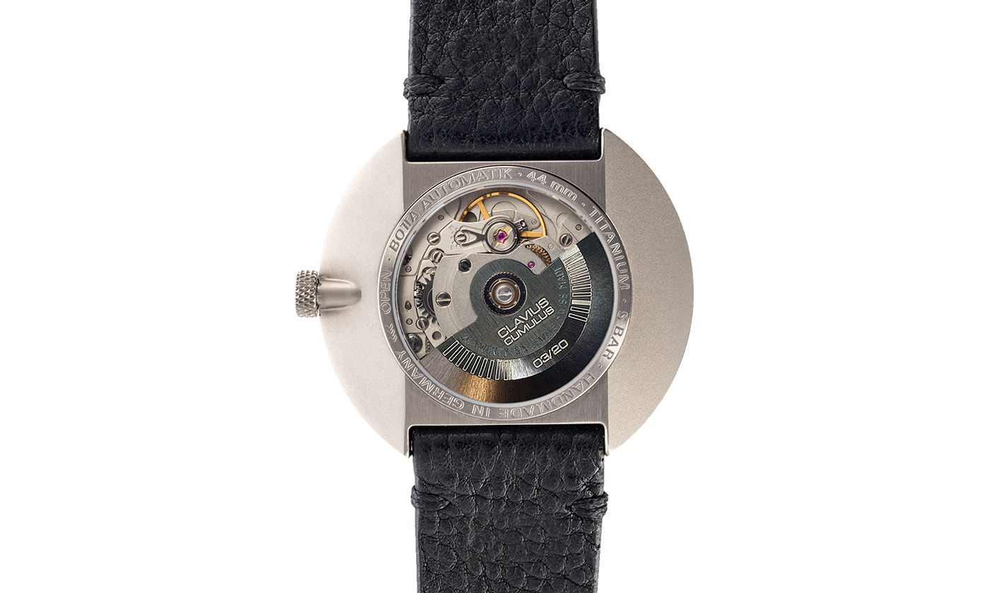 Rückansicht der BOTTA CLAVIUS Cumulus Automatikuhr, die das aufwendig verarbeitete Automatikwerk durch den Glasboden zeigt. Der Rotor ist mit der Gravur „CLAVIUS Cumulus“ und der Limitierungsnummer versehen, was die Exklusivität unterstreicht. Das 44 mm Titan-Gehäuse ist bis 5 bar wasserdicht und handgefertigt in Deutschland. Diese preisgekrönte Designuhr verbindet technische Raffinesse und puristische Ästhetik – eine außergewöhnliche Automatikuhr, die man kaufen bzw. bestellen kann.