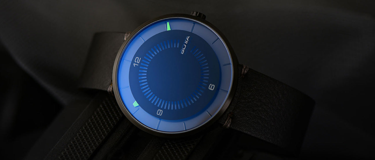 Die BOTTA CLAVIUS Automatik 44 mm präsentiert sich hier in einem geheimnisvoll-dunklen Setting, das die futuristische Anmutung der Designuhr unterstreicht. Das Saphirglas schimmert bläulich, während die grünen Leuchtmarkierungen für präzise Ablesbarkeit sorgen. Eine Einzeigeruhr und Automatikuhr zugleich, gefertigt aus Titan mit Saphirglas. Eine außergewöhnliche Armbanduhr für Designliebhaber, die eine besondere Design-Armbanduhr mit kaufen oder bestellen möchten.