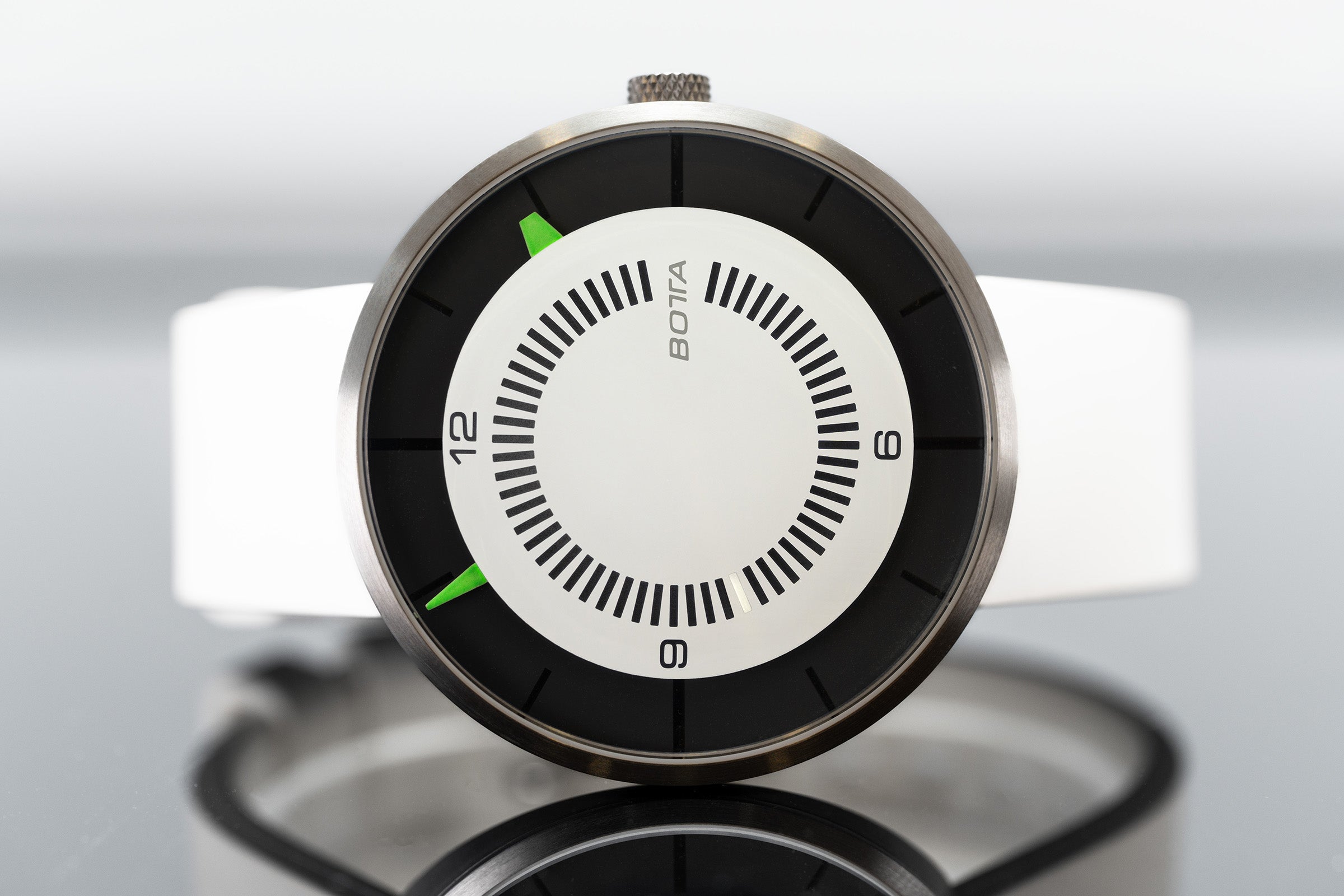 Die BOTTA CLAVIUS Cumulus Automatikuhr in Nahaufnahme zeigt ihr futuristisches, minimalistisches Design. Das weiße Zifferblatt mit schwarzem Kontrastkreis und markanten, leuchtend grünen Indikationen betont die klare Ablesbarkeit dieser Armbanduhr. Mit Titan-Gehäuse, Automatikwerk und handgefertigt in Deutschland vereint sie Technik und Designkunst. Eine preisgekrönte Designuhr für Individualisten – jetzt als exklusive Armbanduhr entdecken, kaufen und bestellen.