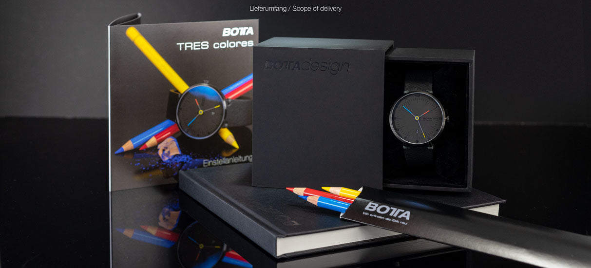 Abgebildet ist die BOTTA TRES colores Automatik im Original-Lieferumfang: hochwertige Verpackung mit Logo, Booklet, Anleitung und die Designuhr selbst. Das Bauhaus-inspirierte Modell überzeugt mit einem schwarzen Zifferblatt und drei Zeigern in Rot, Blau und Gelb. Symbolisch liegen dazu passende Farbstifte bei. Diese Automatikuhr steht für modernes Design, technische Präzision und eignet sich perfekt für Uhrenliebhaber, die eine besondere Armbanduhr kaufen oder bestellen möchten.